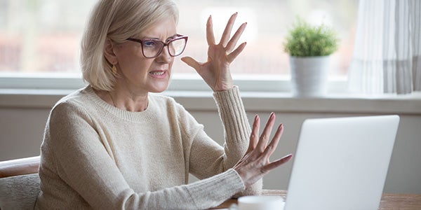 Person showing frustration while reviewing purchase history due to possible fraudulent charges