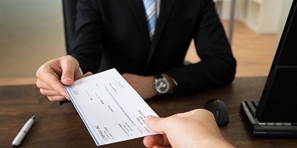 Person giving a check to a bank teller